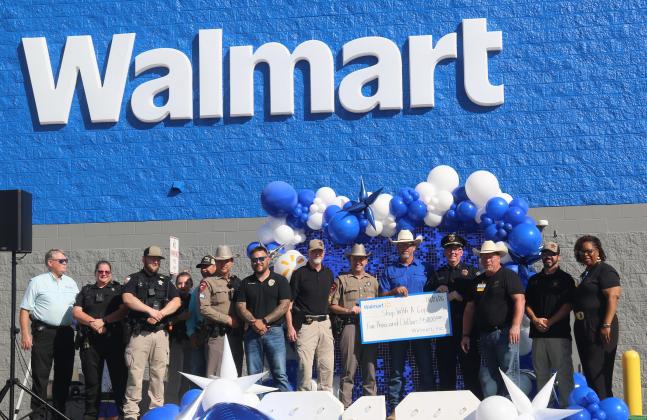 Stephenville Walmart Store Manager Steve McCormick presents a $5,000 check to local law enforcement officers for the annual Shop with a Cop event set for December. The partnership is entering its 6th year and allows children to receive $250 each to shop for whatever they want inside the store for Christmas. Wyndi Veigel- Gaudette | Citizen staff photo