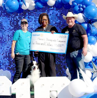 Annie’s Therapeutic Companions, owned by Lyndi Hanna and represented by Hank, accept a check for $5,000 from Walmart. Wyndi Veigel-Gaudette | Citizen staff photo