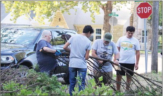 Dublin volunteers and Boy Scouts work to cut up a tree as part of Revitalize Dublin’s first project, a home in need of extensive yard work and TLC located on the corner Blackjack and Harrell. More than 30 volunteers participated in the project. Paul Gaudette | Citizen staff photo