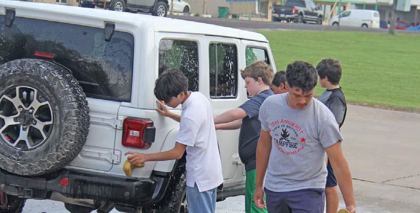 Scouting America Troop 30 diligently cleans a Jeep while a collection of rubber ducks looks on. The Troop hosted a car wash at First National Bank Saturday, April 26 along with a bake sale to raise money. Paul Gaudette | Citizen staff photo