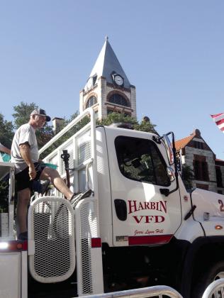 Precinct 1 County Commissioner and Harbin Volunteer Firefighter Dee Stephens waves to crowds from atop a fire truck. Wyndi Veigel-Gaudette | Citizen staff photo