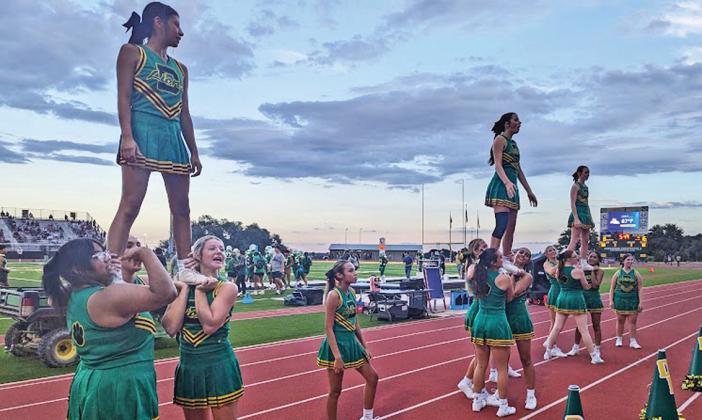 Above, The Sound of Dublin Band play the school song to start the Aug. 30 home game while the Dandi-Lions wave their poms in time with the band’s playing. Right above, Edwin Nevarez lifts teammate DJ Ferguson up in the endzone in celebration of Ferguson’s touchdown. Right middle, Rey Chacon moves to block a DeLeon Bearcat. At right, Dublin cheerleaders get raised up for a roller coaster inspired cheer to motivate the crowd Paul Gaudette | Citizen staff photo