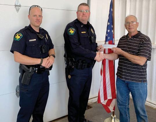 Ben Pate makes a donation to Shop with a Cop on behalf of the Dublin Rotary Club. Submitted photo