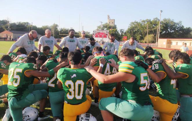 Varsity Lions take a knee to pray with their coaches before facing the Hamilton Bulldogs Friday, Aug. 16 on Hamilton’s Kooken Field. Paul Gaudette | Citizen staff photo