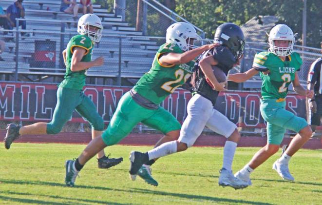 JV Lions flank a Hamilton runner during the Aug. 16 scrimmage. Paul Gaudette | Citizen staff photo