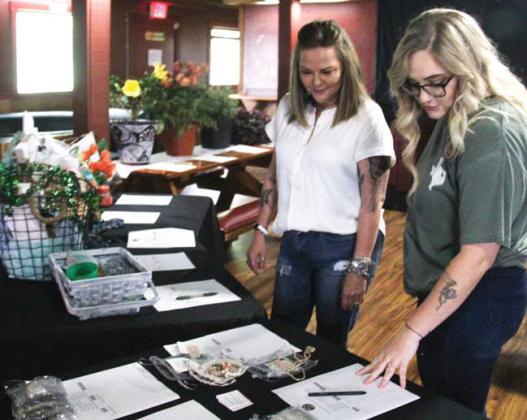Bidders look over silent auction items at the Revitalize Dublin fundraiser at Backwoods Saturday, April 27. A variety of auction items were donated by local businesses for the event. Paul Gaudette | Citizen staff photo
