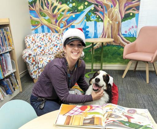 Hank enjoys looking at a Christmas book with his handler, Lyndi Hanna. The duo are part of Annie’s Therapeutic Companions and often come to the Dublin Public Library so kids can practice their reading skills. Paul Gaudette | Citizen staff photo