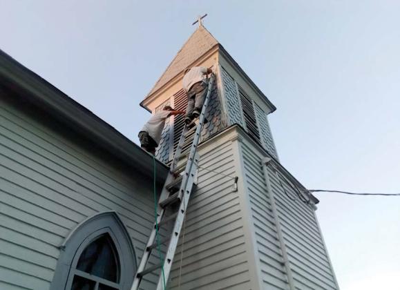 Volunteers work on stripping and painting the Little Church on Grafton as a renovation project. Courtesy photo