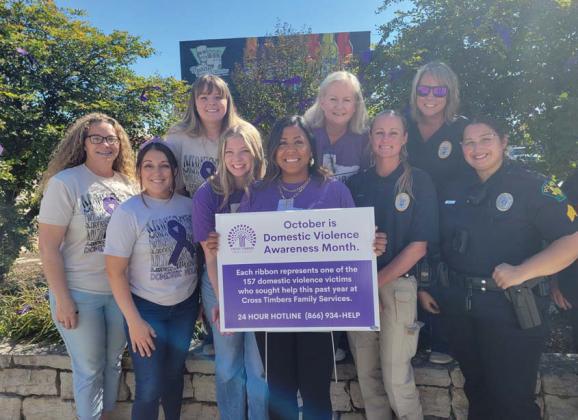 Staff from Cross Timbers Family Services, volunteers, survivors of domestic violence and members of the Dublin Police Department tie ribbons on trees at the Corner Lot in honor of Domestic Violence Awareness Month. (Not pictured but present at the event is SRO Sergeant Jacob Ivie.) Wyndi Veigel-Gaudette | Citizen staff photo