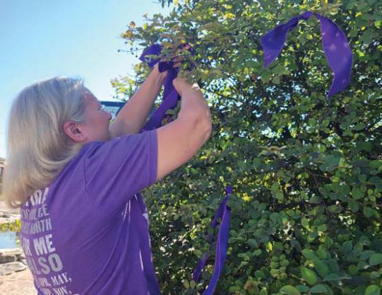 CTFS Executive Director Laura Gambino ties purple ribbons at Dublin’s Corner Lot. Wyndi Veigel-Gaudette | Citizen staff photo