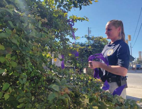 SRO Brandi Hoffman ties purple ribbons in support of October’s Domestic Violence Awareness Month. Wyndi Veigel-Gaudette | Citizen staff photo