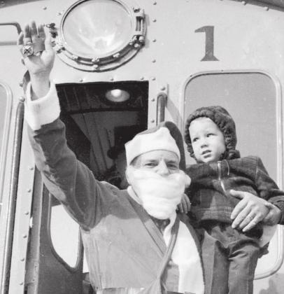 Greeting Santa aboard the Texas Central Railroad locomotive is three-year-old Kevin Lee Yarbrough of Arlington. This special Santa excursion was made possible by Engineer Lyndell Coan, Brakeman Bob Huddleston and Dublin Agent Edwin C. Stafford. | Dublin Historical Museum Archive photo