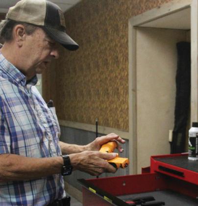 School Resource Officer Jacob Carpenter practices a hostage situation scenario (right) at Locked and Loaded Training Center, a new high tech firing range located at 205 North Patrick across from Brookshire Brothers. Above, Keith Nichols shows off the modified Airsoft guns used in the electronic range. Paul Gaudette | Citizen staff photo