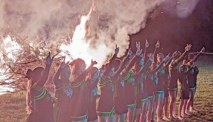 Dublin cheerleaders ( above) lead the crowd in the school song in front of a bonfire at a Nov. 1 pep rally at Double N Cowboy Church while Lions football players join in the reverence. Paul Gaudette | Citizen staff photo