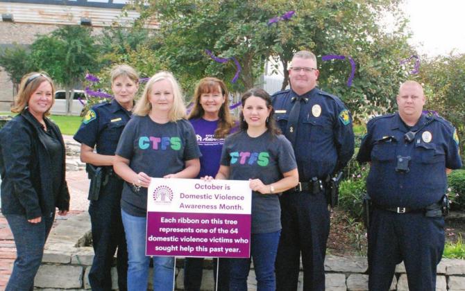 Members of the Dublin Police Department and Cross Timbers Family Services joined together last week to tie purple ribbons around the corner lot in recognition of October as Domestic Violence Awareness Month. Corrie Conner | Citizen staff photo