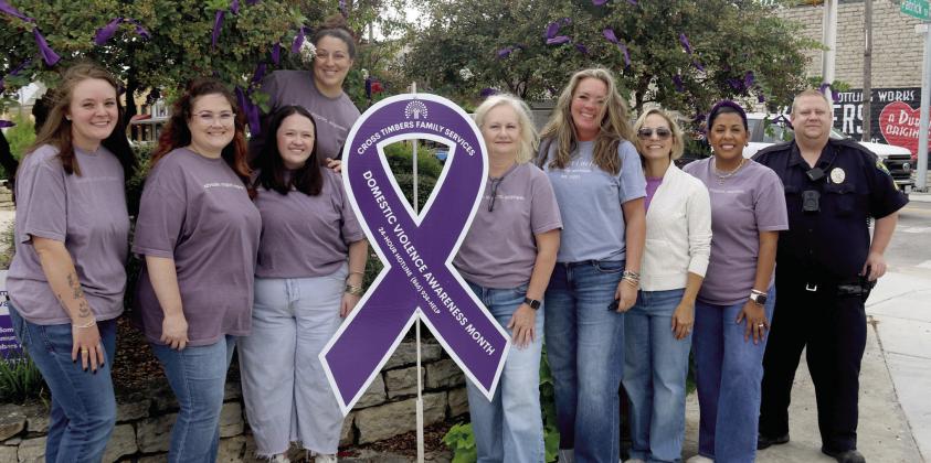 Volunteers and employees with Cross Timbers Family Services and Dublin PD SRO Sgt. Jacob Ivie tie purple ribbons to trees at the Corner Lot representing the 172 people helped in Erath County over the past year as victims of family violence. October is Domestic Violence Awareness Month. Wyndi Veigel-Gaudette | Citizen staff photo