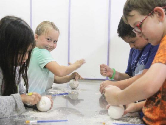 Kids of all ages work to uncover fossils inside of dinosaur eggs. Wyndi Veigel | Citizen staff photo