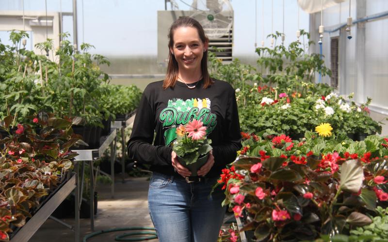 Plant photo with ag sponsor Sophie Hayhurst. She is holding a gerber daisy plant.