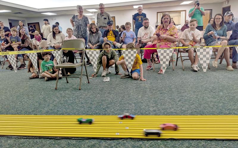 Audience members watch in fascination as cars zoom by at the annual Pinewood Derby held Saturday, March 21 at First Methodist Church. Paul Gaudette | Citizen staff photo