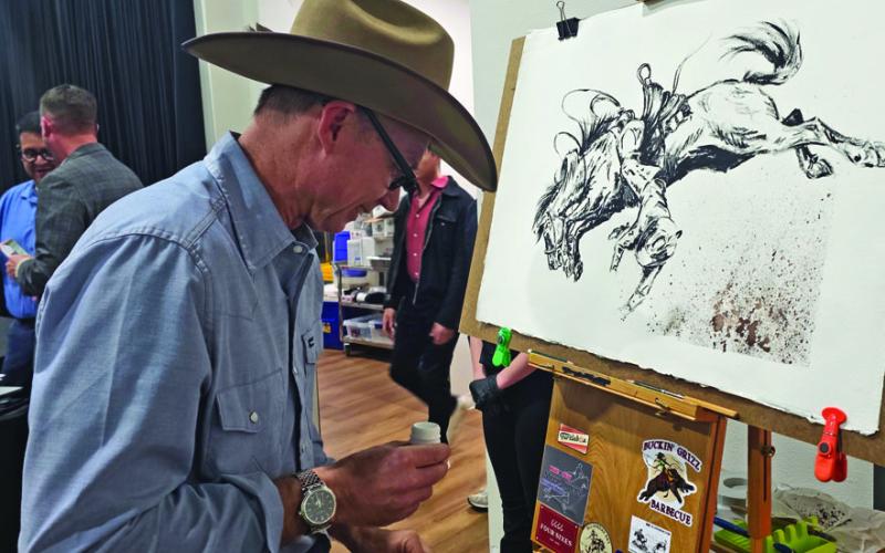 Blu Dornan works on a hand painted ink drawing to be auctioned off at the annual CTFAC fundraising dinner. Wyndi Veigel-Gaudette | Citizen staff photo
