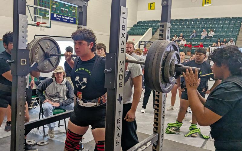 Dublin Lion Jayden Balvantin (above) stacks the weights during the squat portion of the Dublin Invitational Powerlifting Meet while teammates stand by to spot. Annabelle Delgado (below) dips down while coach Hannah Smith drops to check her form and cheer her on. Paul Gaudette | Citizen staff photo