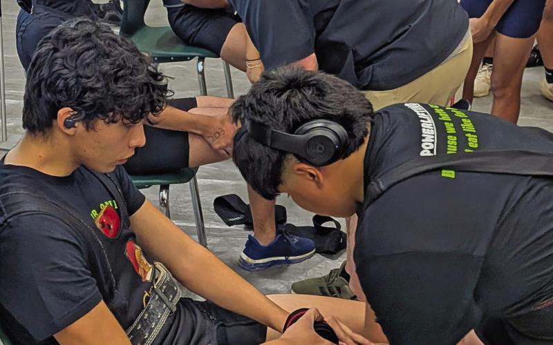 Dublin Lion powerlifters are helped with knee wraps prior to taking the bar in the squat portion of the Dublin Invitational Powerlifting Meet Saturday, Feb. 21. Paul Gaudette | Citizen staff photo