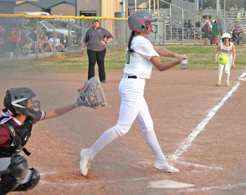 Paul Gaudette | Citizen staff photo Dublin Lady Lion Olivia Salyer swings to hit while teammate Libby Turner steps off third to make a break for home plate during the Feb. 28 home game against DeLeon.