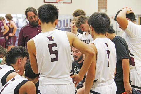 Lingleville Cardinals and assistant coach Jim Bays look to Lingleville boys head basketball coach for strategy during the Friday, Feb. 16 playoff warm-up game against Zephyr.