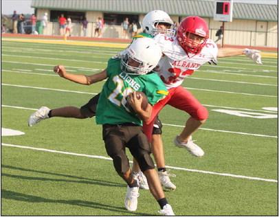 An 8th-grade Dublin Lion gets snagged by an Albany Lion moving up the field as a teammate moves in to help. The Dublin boys fought hard, putting up 24 to Albany’s 36 in the first game of the 2023 season on the Cervetto Field turf Thursday, Aug. 31. Paul Gaudette | Citizen staff photo