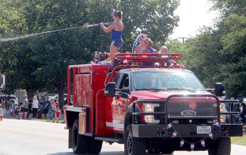 Those riding on a firetruck in the Stephenville July 4th parade cool down parade goers by spraying them with water. Wyndi Veigel | Citizen staff photo