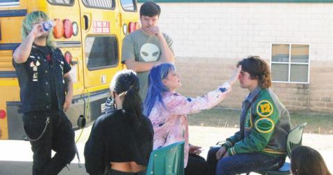 Dublin High School senior Colton Moore sits down for makeup so he can go on camera for a professional music video shot at Dublin Secondary last week. The artist and music label were kept quiet but will be announced when the video premieres late in October. At right, equipment was set up around a Dublin school bus to use it in the shoot. Paul Gaudette | Citizen staff photo