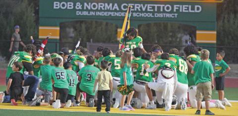 Dublin Lions and young fans kneel in the endzone before a recent home game. Paul Gaudette | Citizen staff photo