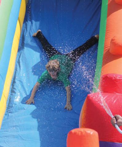 Kids of all ages enjoy sliding down a water slide at the Elementary School Field Day. Wyndi Veigel | Citizen staff photo