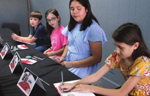 Authors Weston, Emery, Ana and Addy sign copies of their book, “Mission to Mars”, which they wrote and illustrated with fellow authors, Evie, Olivia, Robbie and Rustie in a workshop held by Dublin’s Little Authors last July. The bilingual publication is being sold in store and online. Paul Gaudette | Citizen staff photo