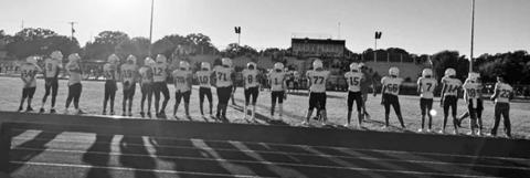 Shadows stretch on the track as 8th grade Lions stand on the sideline. | Submitted photo