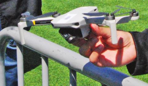 Dublin teacher/coach Dondrei Williams (below, right) shows student Bryan Rios some helpful tricks when flying the DJI Mini 1 (above). Paul Gaudette | Citizen staff photo