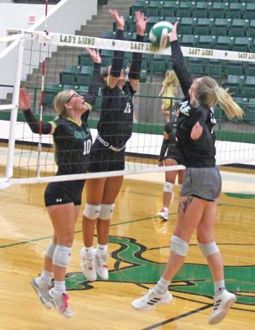 Lady Lions Summer Anderson and Olivia Salyer (left) spring up to meet alum Madilyn Loper during an Aug. 20 varsity vs. alumni game in the Roy and Lynn Neff Gym. At Left, Bailey Watson and ref Greg Cisneroz supervise a rock paper scissors match between Anderson and DABC President Ryan Mitchell. Paul Gaudette | Citizen staff photo