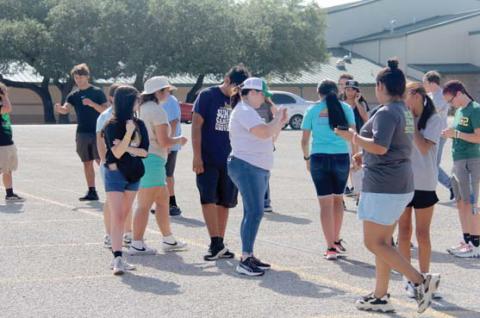 Band Director Cathryn Smith shows band students the correct placement of where they should be standing through an app. Below, students move into the correct place in their upcoming marching routine. Wyndi Veigel-Gaudette | Citizen staff photos