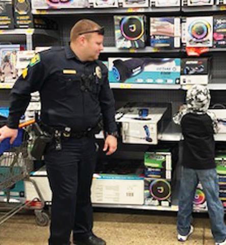 Dublin Police Sergeant Khris Jennings helps a youngster pick out a hoverboard during Erath County’s Shop with a Cop event, Thursday, Dec. 22. Submitted photo