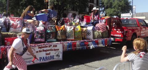 Terah Bradberry runs alongside the Bradberry's Best float in the Stephenville July 4th parade handing out trinkets. Feed for sale was also showcased on the parade entry. Wyndi Veigel-Gaudette | Citizen staff photo
