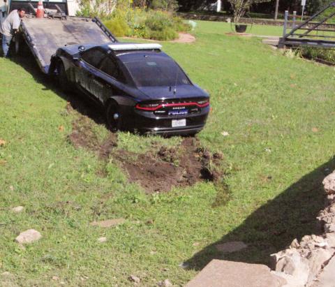 A Dublin cruiser is hitched up for towing after going through the rock wall on the North Park side of the Dublin Public Library. Paul Gaudette | Citizen staff photo
