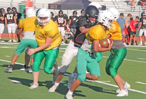 A Dublin JV Lion cuts around Hamilton Bulldog defense while teammates block during a scrimmage on Friday, Aug. 11 at Cervetto Field. Paul Gaudette | Citizen staff photo