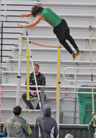 Paul Gaudette | Citizen staff photo Dublin Lion Travis Spharler (above) vaults over the bar at the Dublin Invitational track meet Thursday, March 6 while Olivia Salyer (right) launches into the sand during the long jump event.