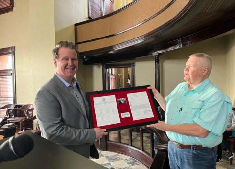 County Judge Brandon Huckabee was presented with a framed copy of his very first agenda as newly elected county judge by citizen Vince Parro. Submitted photo
