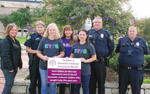 Members of the Dublin Police Department and Cross Timbers Family Services joined together last week to tie purple ribbons around the corner lot in recognition of October as Domestic Violence Awareness Month. Corrie Conner | Citizen staff photo