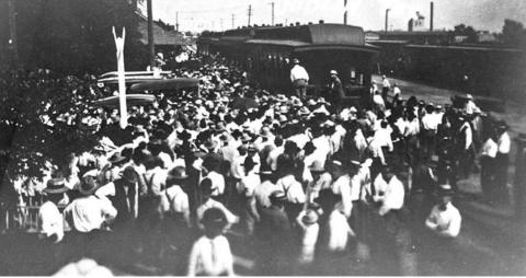 Jake Hamon first came to Dublin in June 1918 to discuss the new railroad he was building. He brought a contract to the Dublin railroad committee on October 1, 1919. This photo shows him being met by a crowd at the MKT station. The tower for the cotton compress can be seen on the horizon to the right. | Dublin Historical Society archive photo