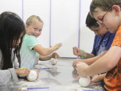 Kids of all ages work to uncover fossils inside of dinosaur eggs. Wyndi Veigel | Citizen staff photo
